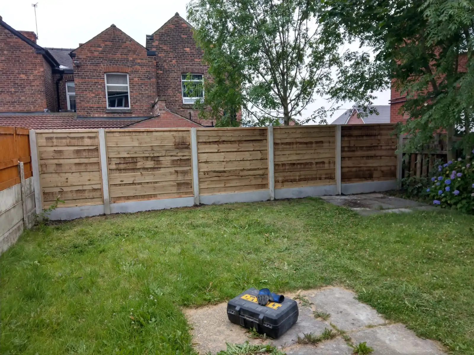 Horizontal lap panel fencing with concrete posts and gravel boards in residential garden